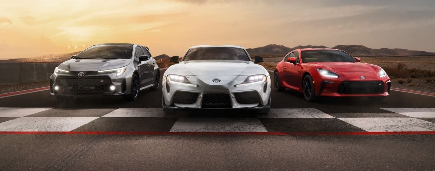 Silver 2023 Toyota GR Corolla, Orange 2023 Toyota GR Supra, and 2023 Toyota GR86 parked together