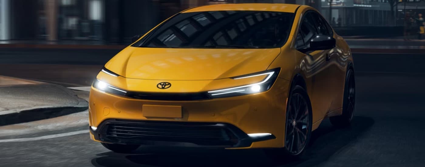 A yellow 2025 Toyota Prius driving in a city.