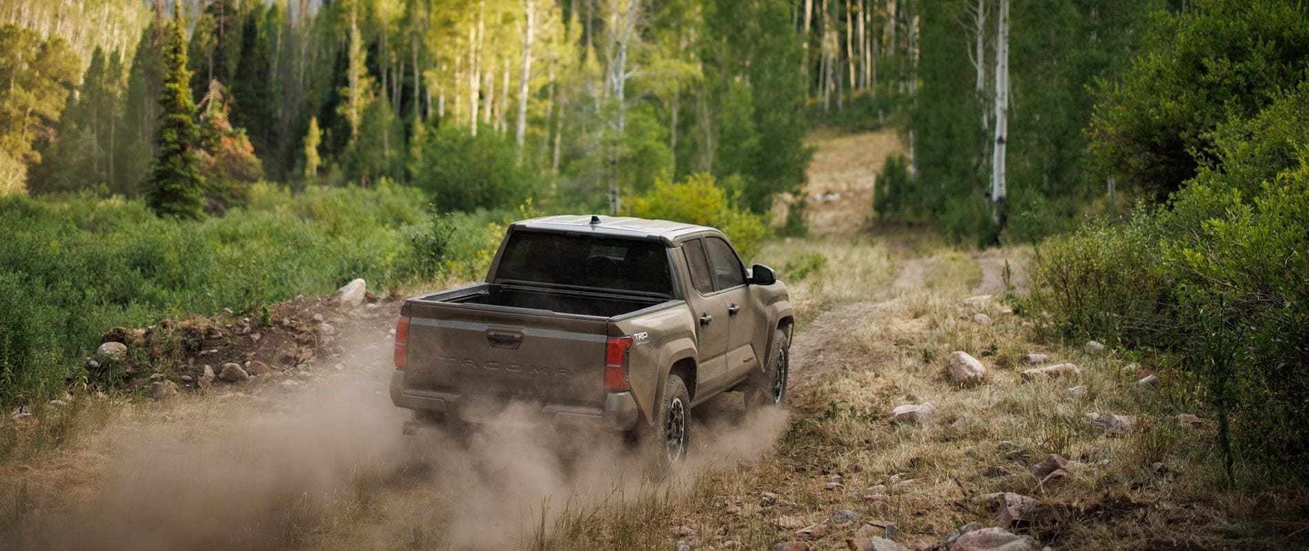 2025 Toyota Tacoma driving on a wooded path