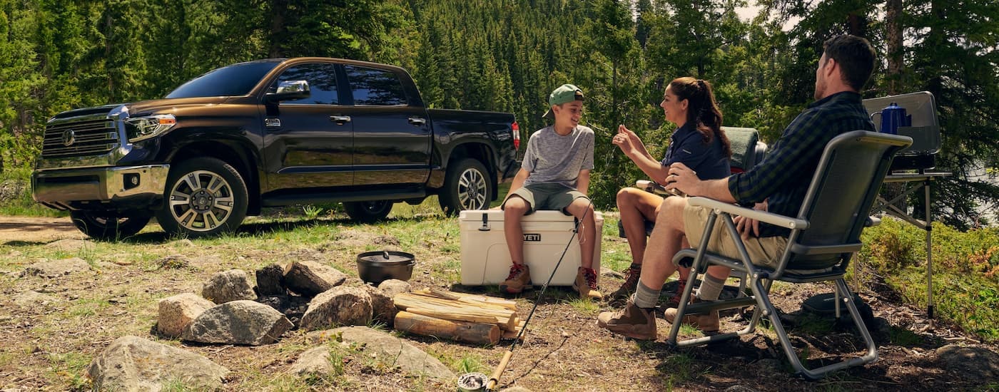 A family camping next to a brown 2021 Toyota Tundra