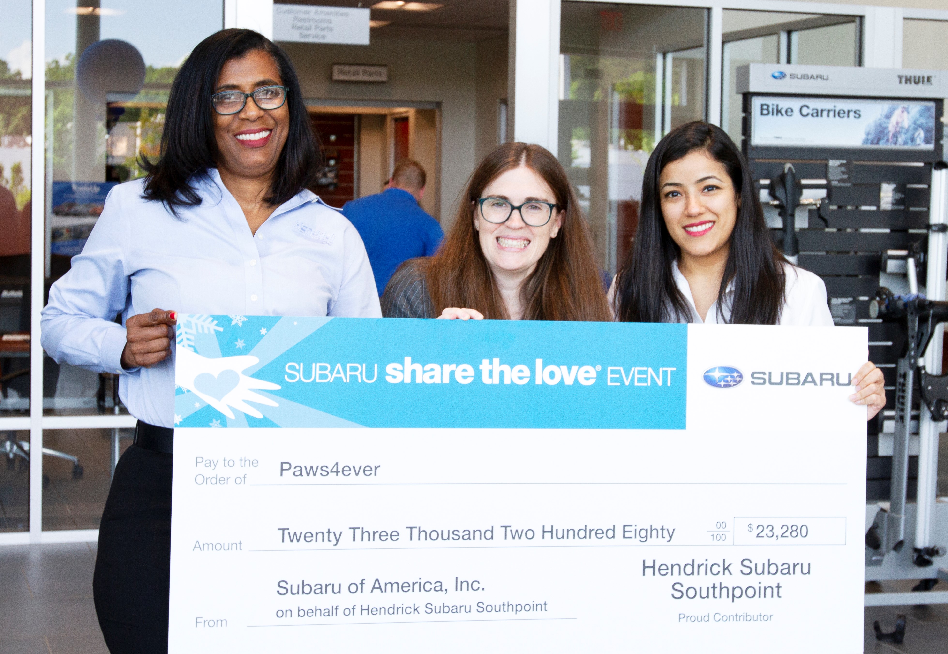 Hendrick Subaru Southpoint General Manager Anna Latta and Marketing Director Poonam Nandani present Paws4Ever with Share the Love donation check.