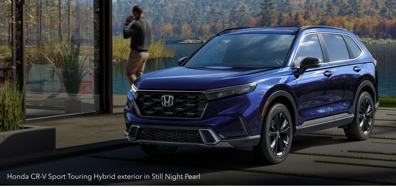 Honda CR-V Sport Touring Hybrid exterior in Still Night Pearl on a modern driveway.