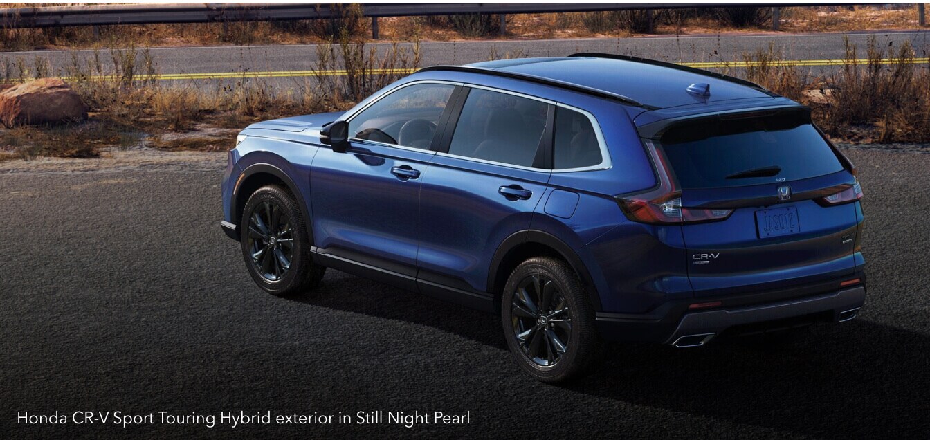 Honda CR-V Sport Touring Hybrid exterior in Still Night Pearl on a roadside turnout.