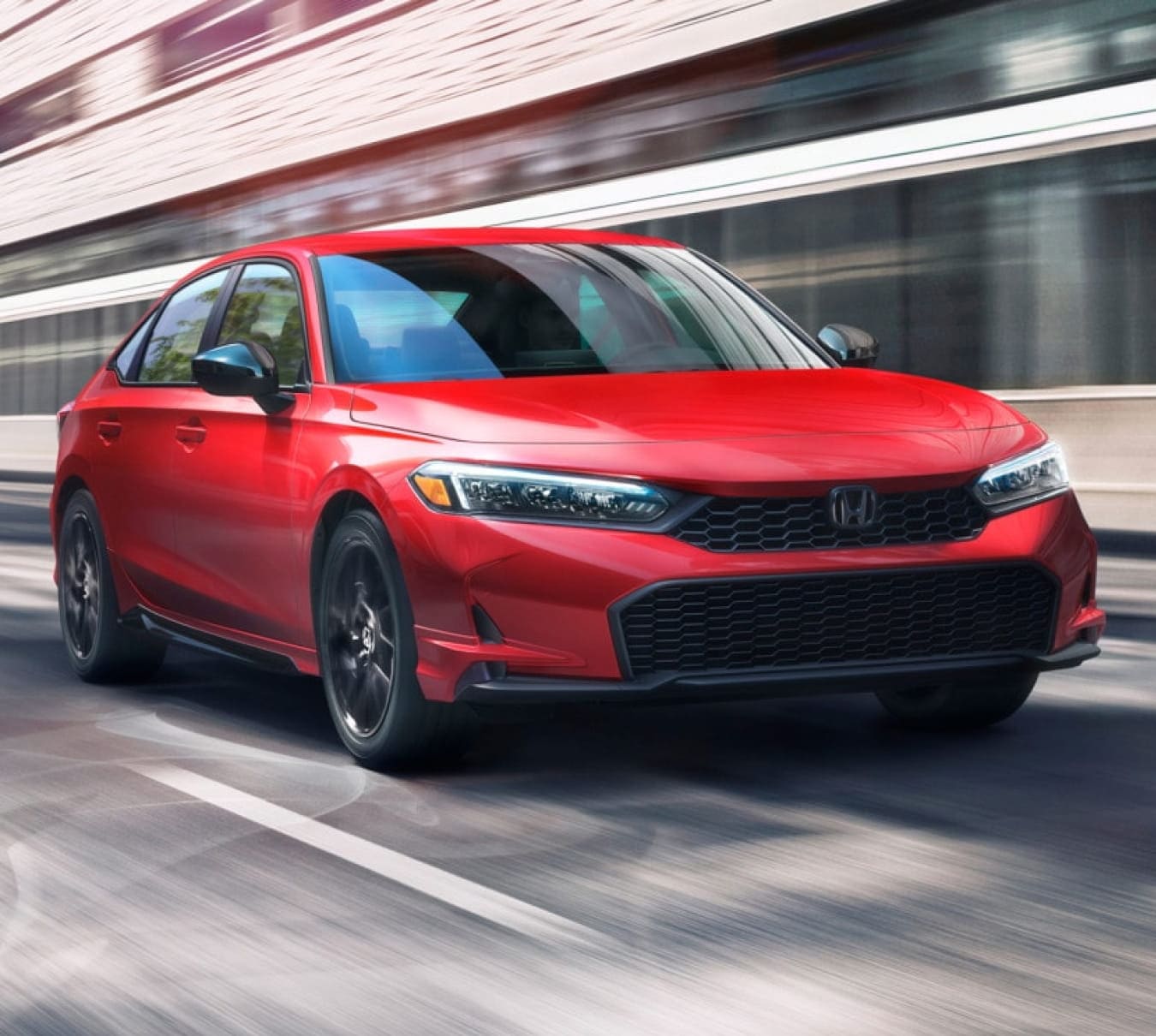 2026 Honda Civic Sedan Hybrid in motion on a city street.