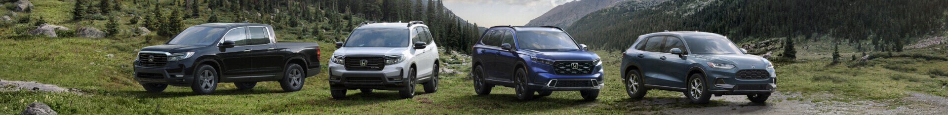 A lineup of l2023 Honda trucks and SUVs parked in a mountain clearing.
