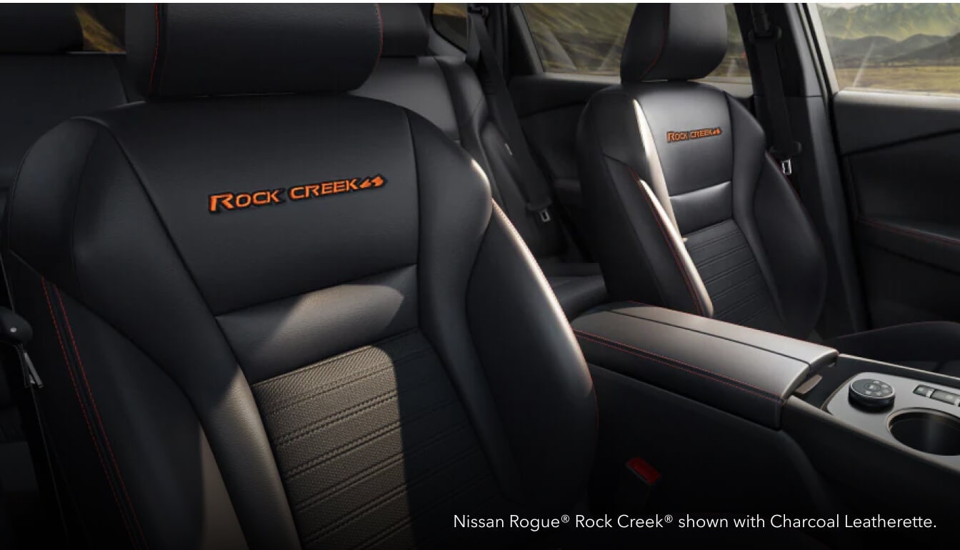 Close-up interior view of the front bucket seats featuring a Nissan Rogue Rock Creek with Charcoal Leatherette interior.