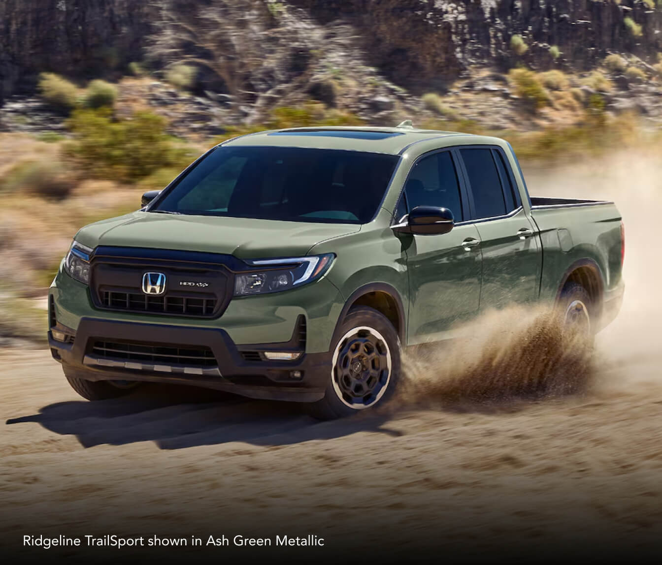 Ridgeline TrailSport showin in Ash Green Metallic driving down a dirt road