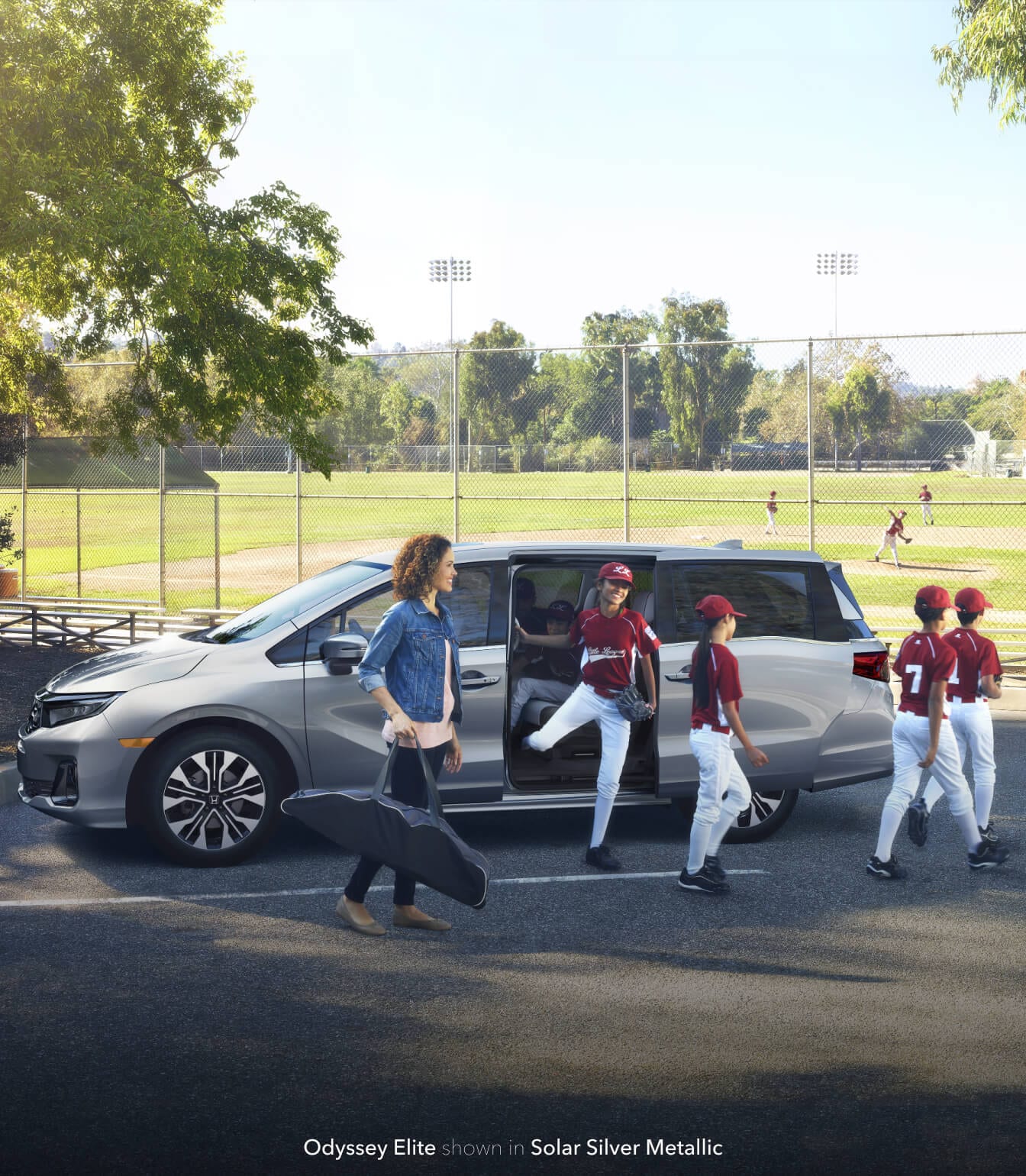 Woman and children exiting the Honda Odyssey Elite in solar silver metallic