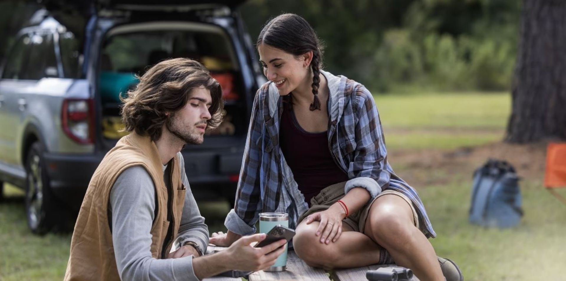 A person looking at the FordPass app while camping.