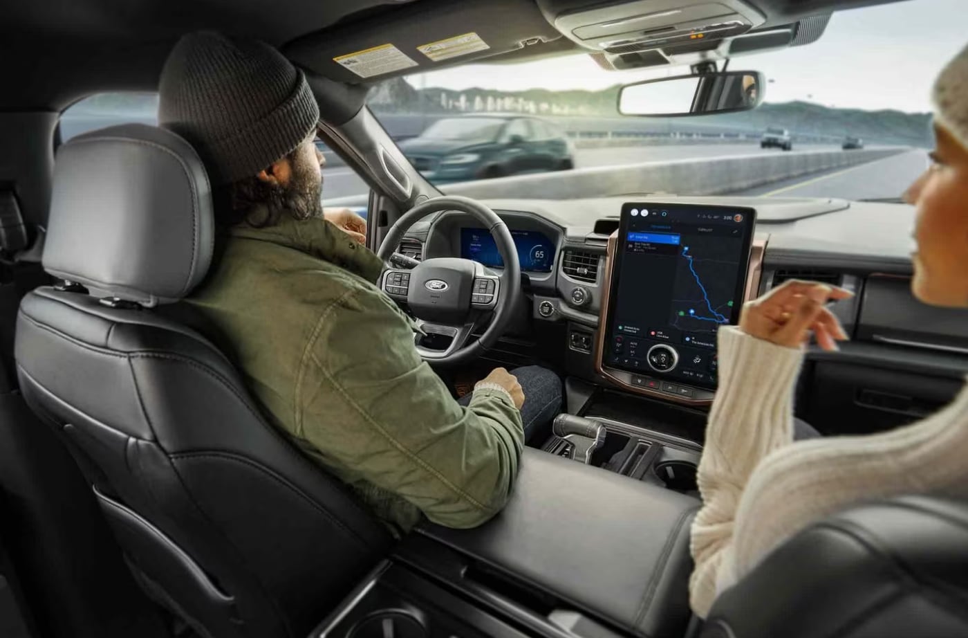 The interior of a Ford truck while driving down an interstate.