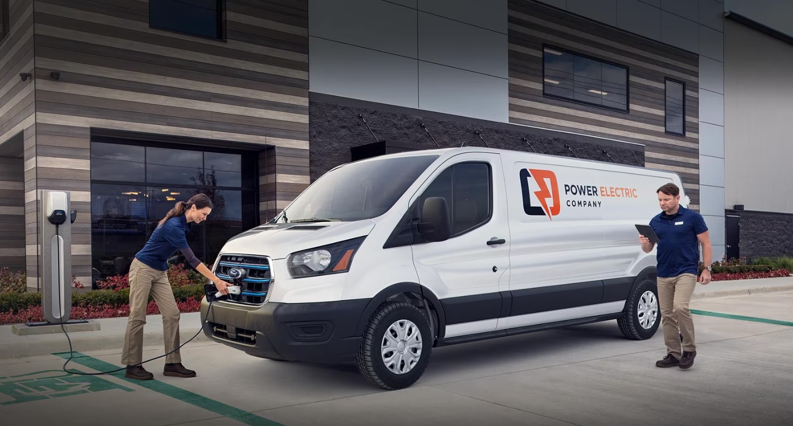 Man and Woman plugging charging chord into their van