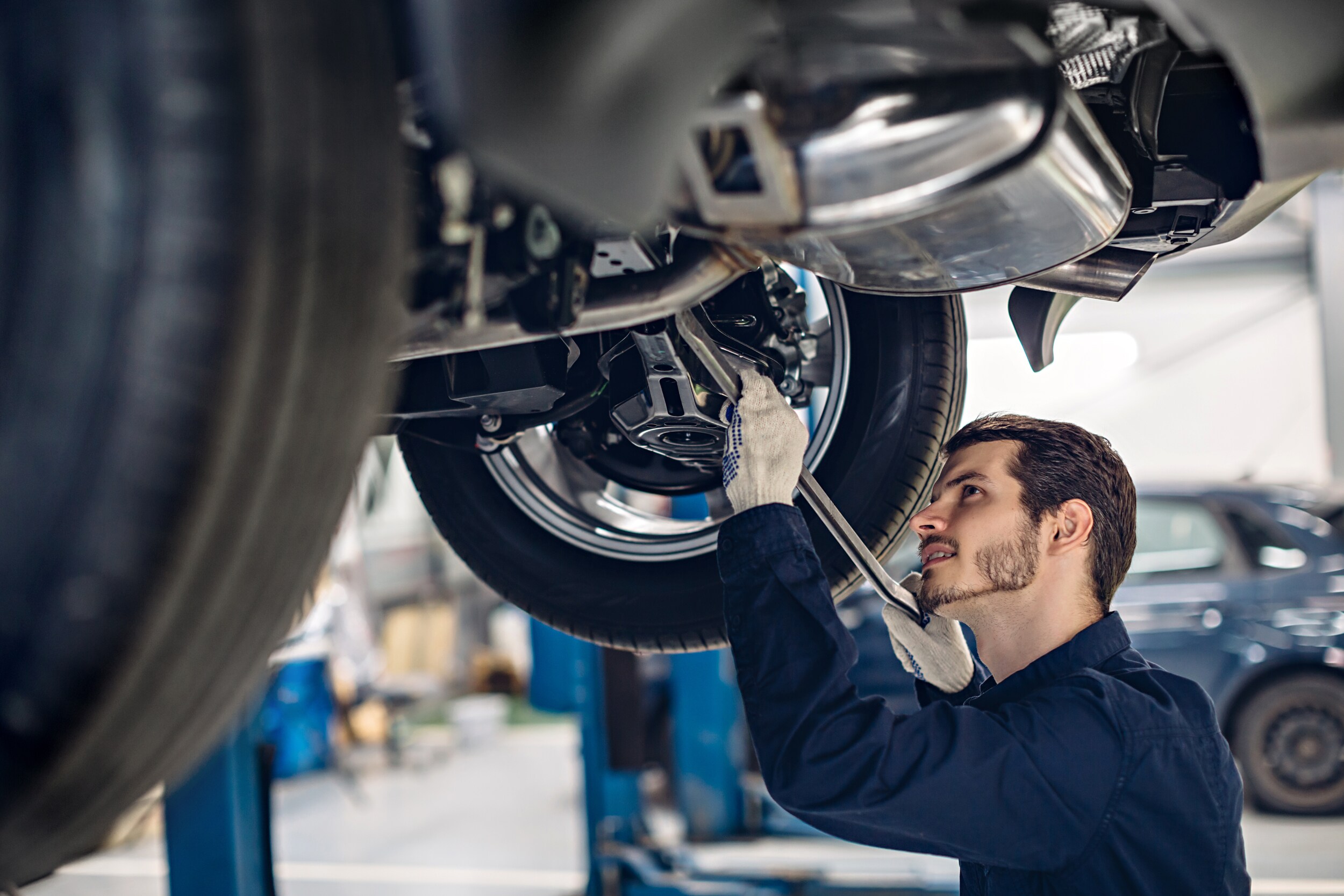 A mechanic working underneath a vehicle.
