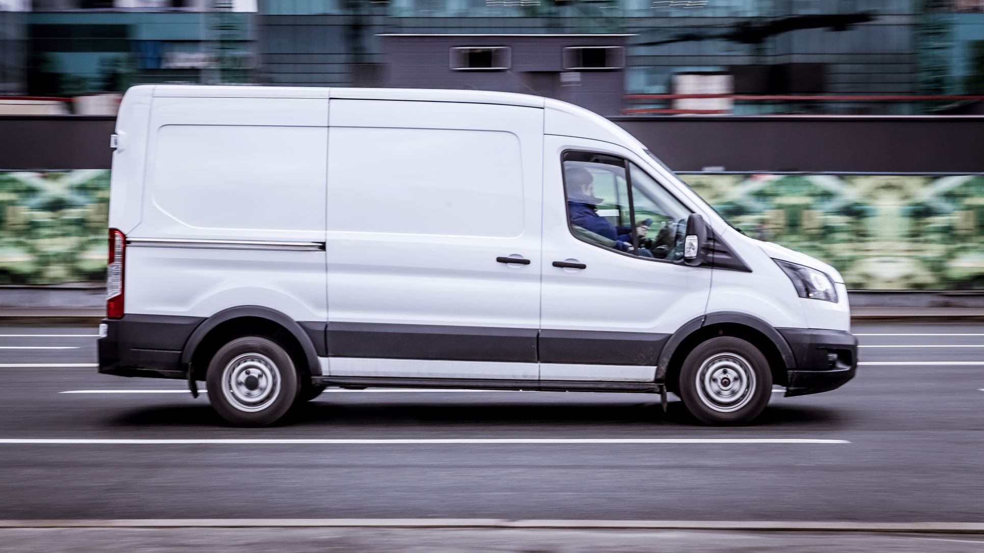 A Ford Transit van driving down a road.