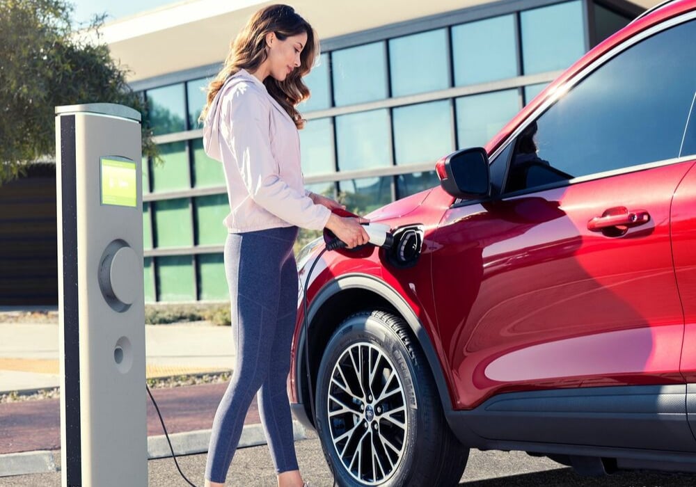 Woman plugging in her 2020 Ford Escape Hybrid to charge