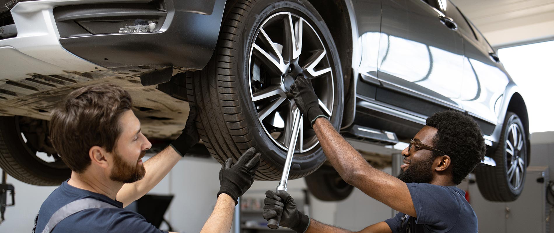Technicians performing tire service on a Ford