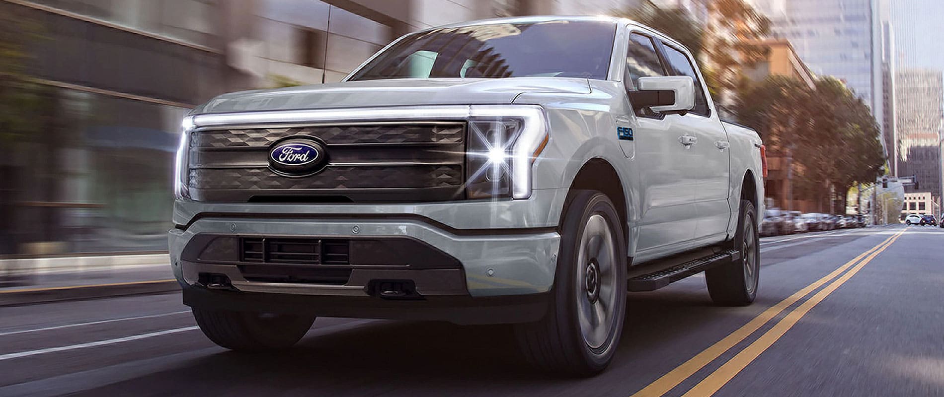 2025 Ford F-150 Lightning driving down a city road