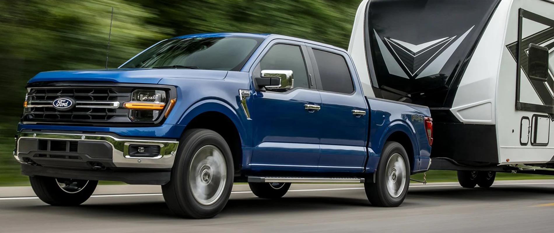 A blue 2025 Ford F-150 pulling a camper 