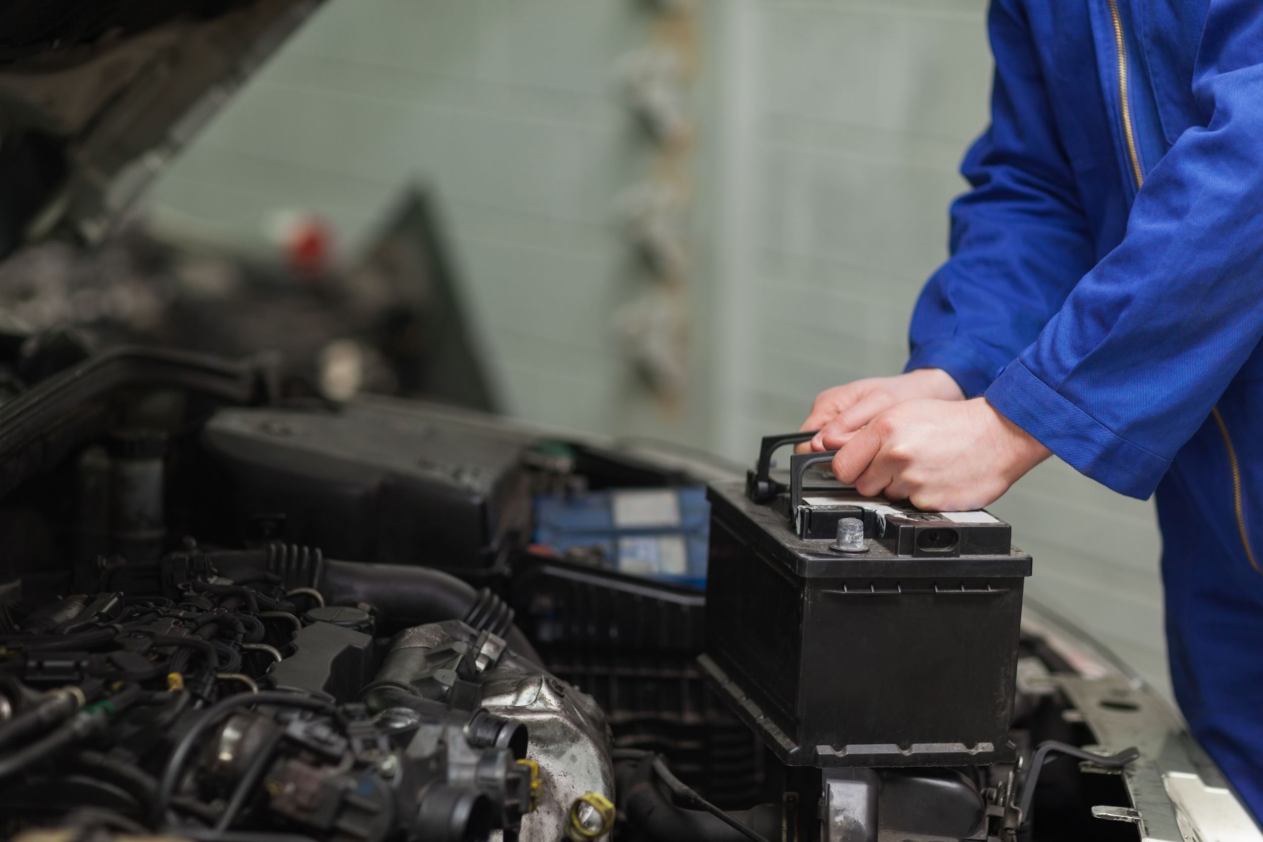 A technician replacing a battery inside a vehicle.