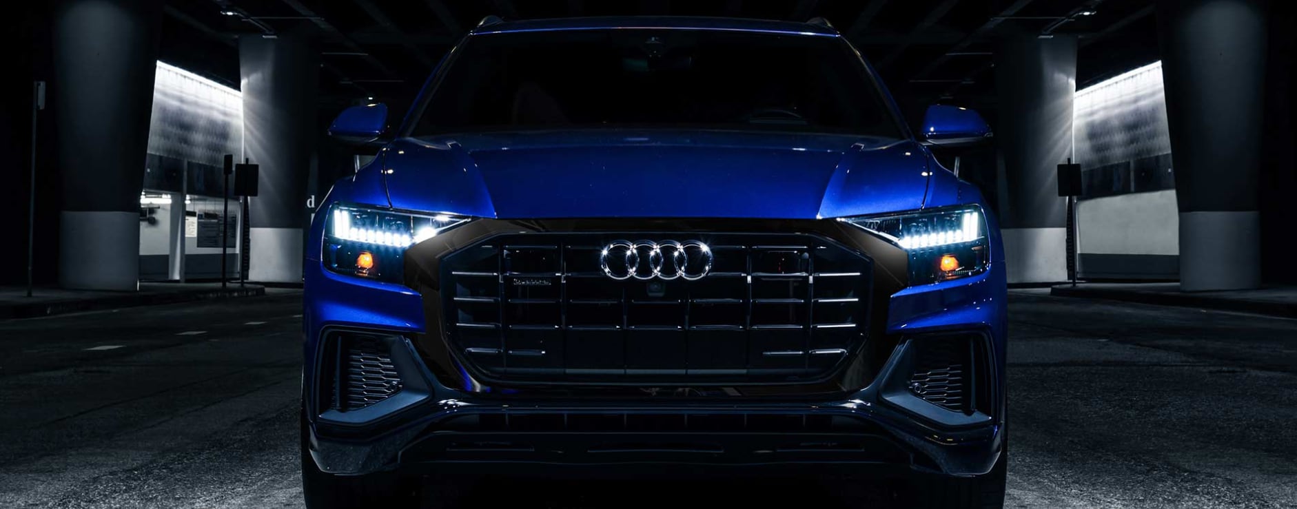 A close-up view of the grill and front of an electric blue 2023 Audi Q8