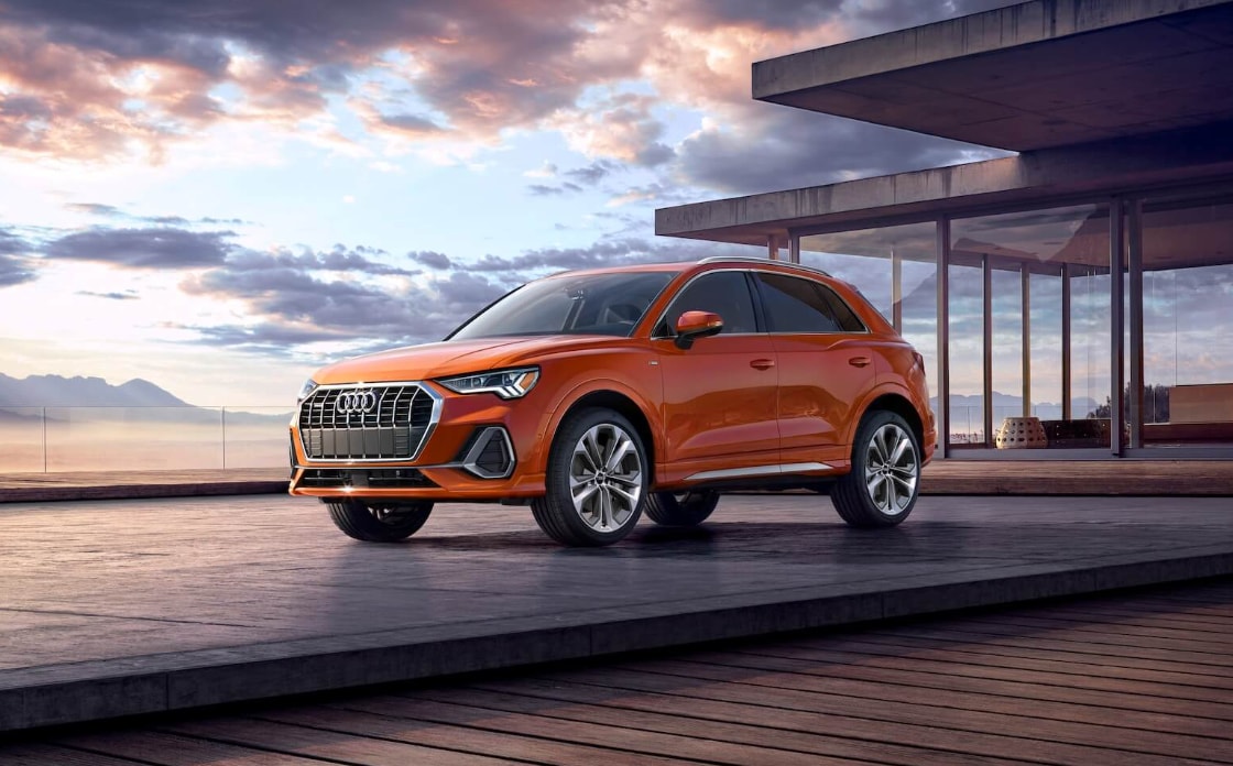 A Pulse Orange 2022 Audi q3 parked outside of a Luxury Family Home