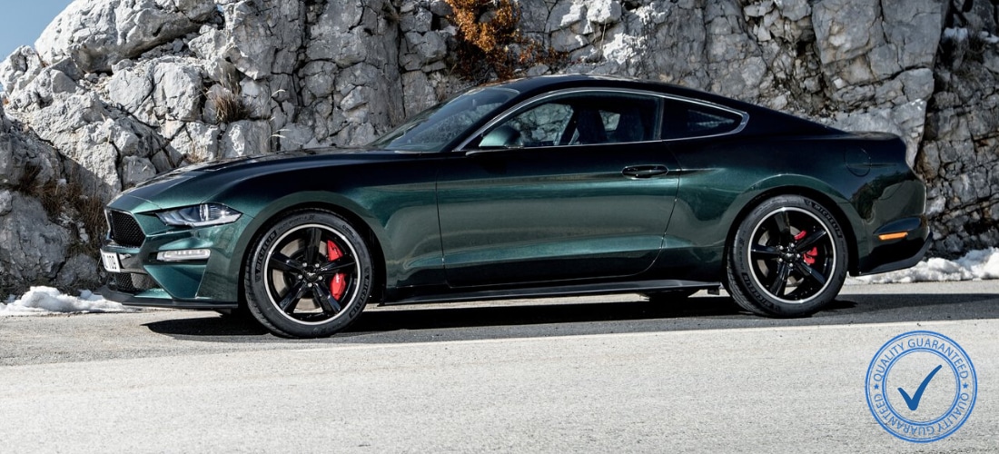 Ford Mustang Bullitt parked on a Rocky Mountain road with a stamp of approved quality