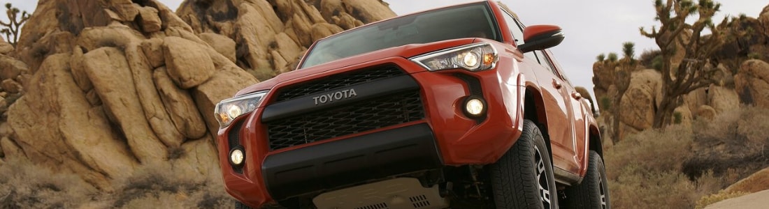 Toyota 4Runner TRD climbing over a dirt hill on a desert path