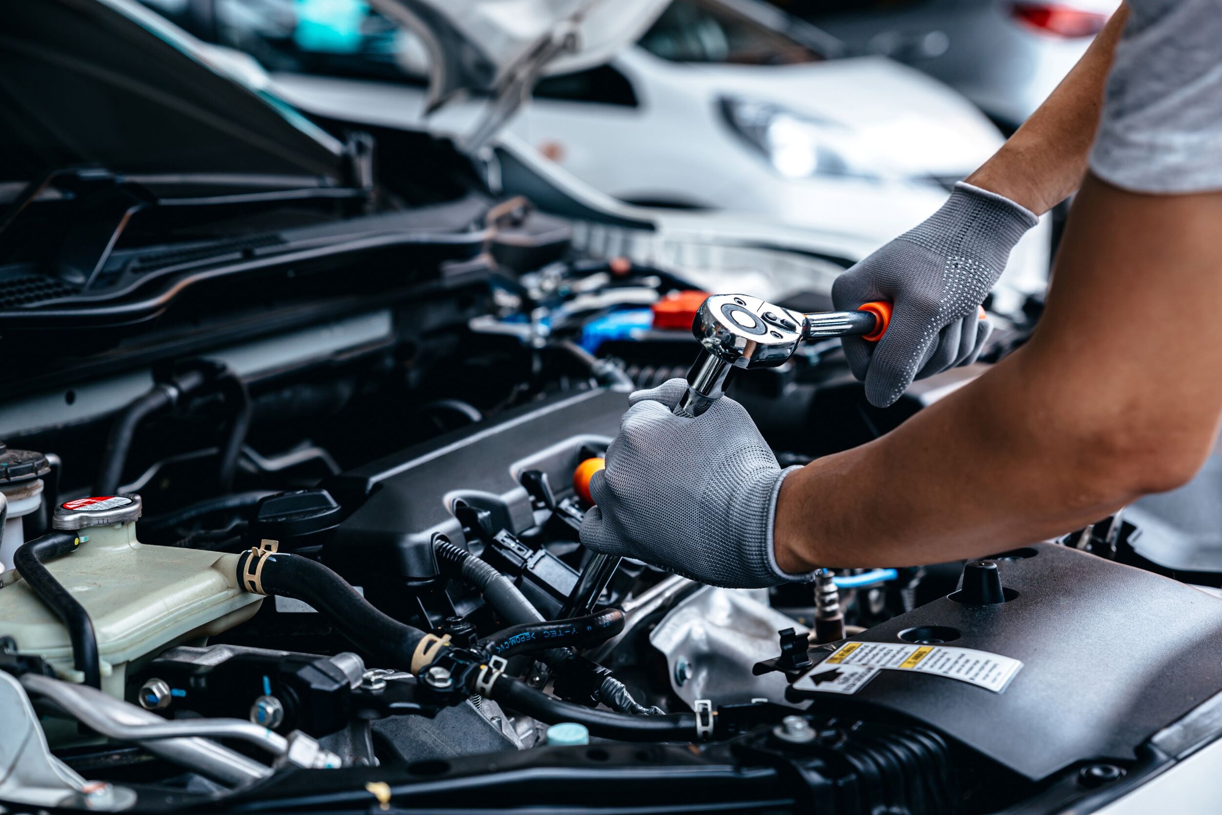 A mechanic working on an engine of a car.