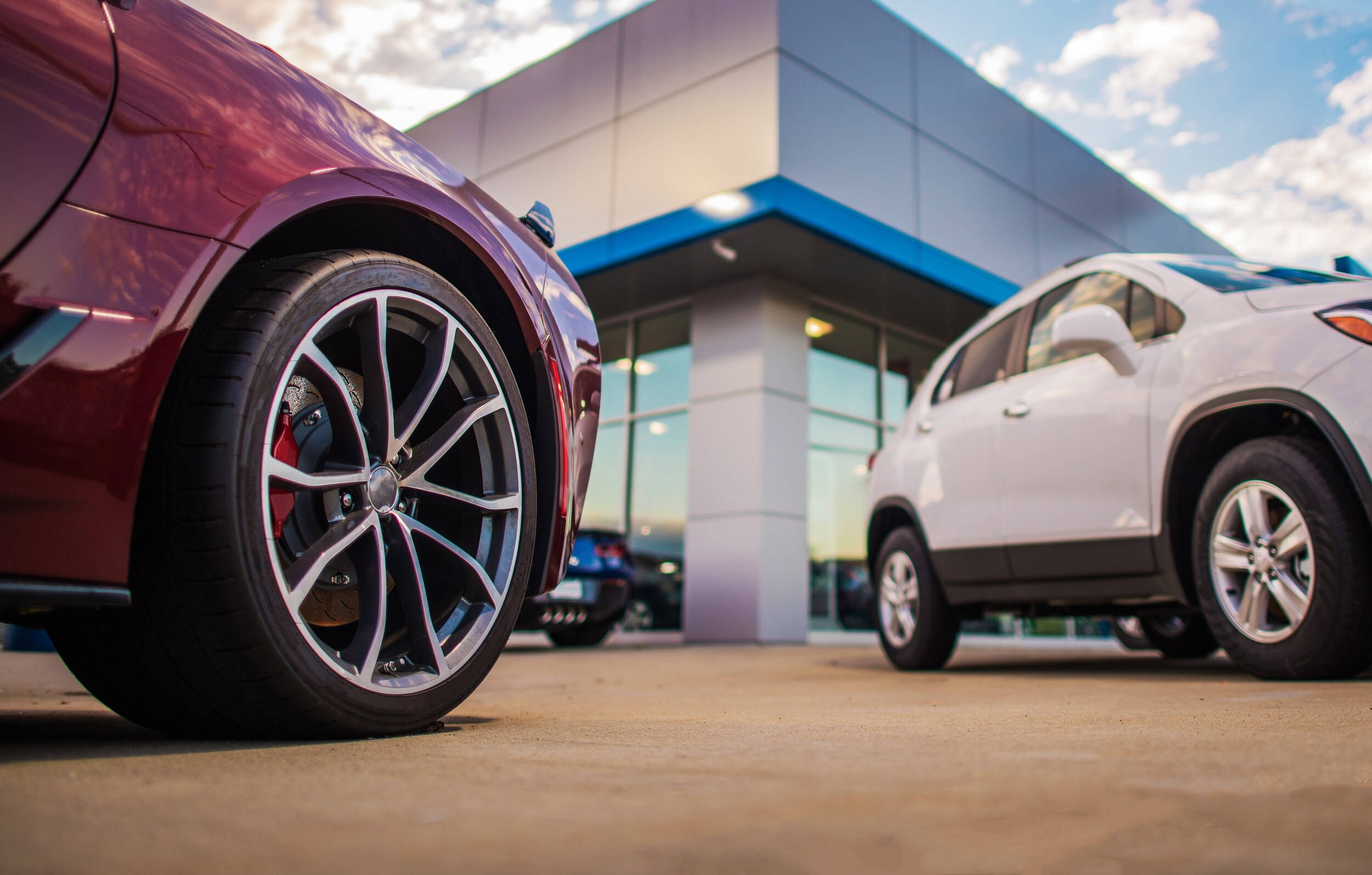 Two cars on display in front of a car dealership.