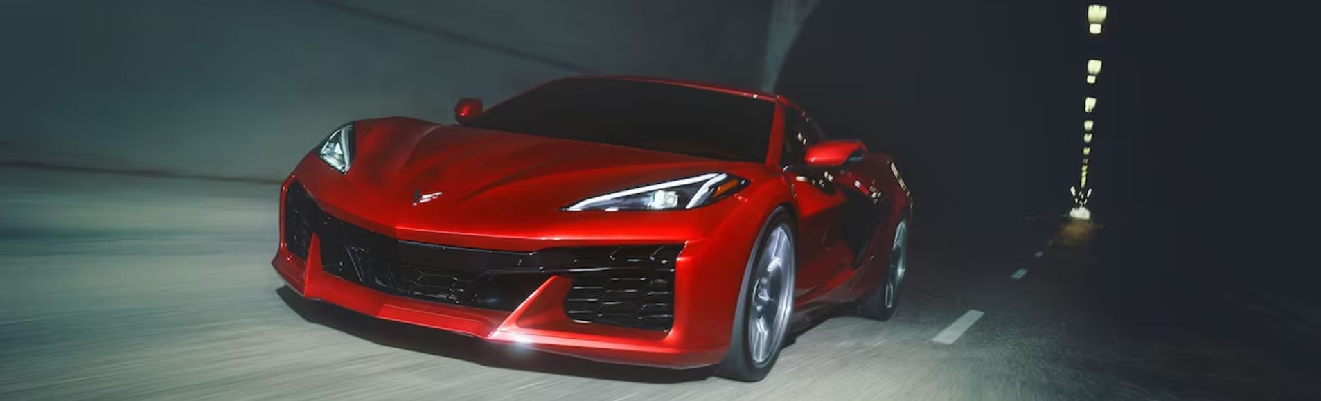 A red 2023 Chevy Corvette drives in a tunnel
