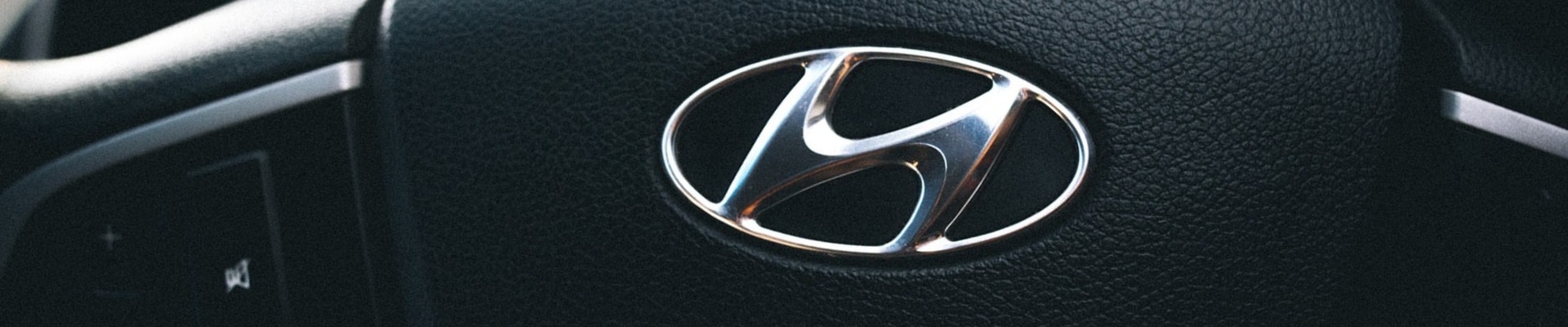 Zoomed in angle of a Hyundai logo on the steering wheel of a certified pre-owned Hyundai vehicle