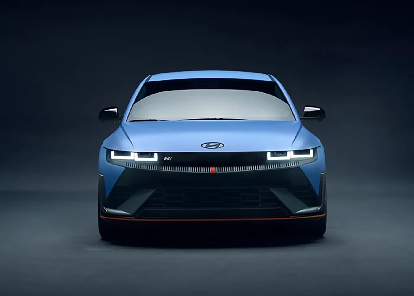 The front of a blue 2025 Hyundai Ioniq 5 N showcased on a dark showroom.