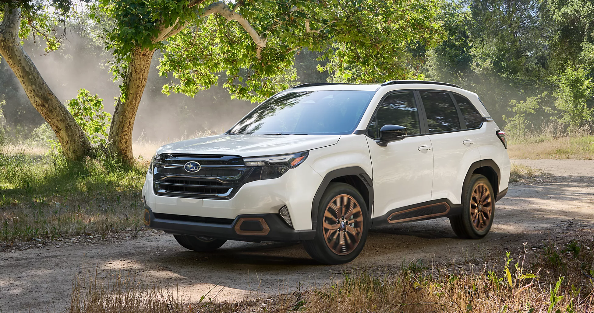 A white 2025 Subaru Forester driving on a dirt road in the Forest.