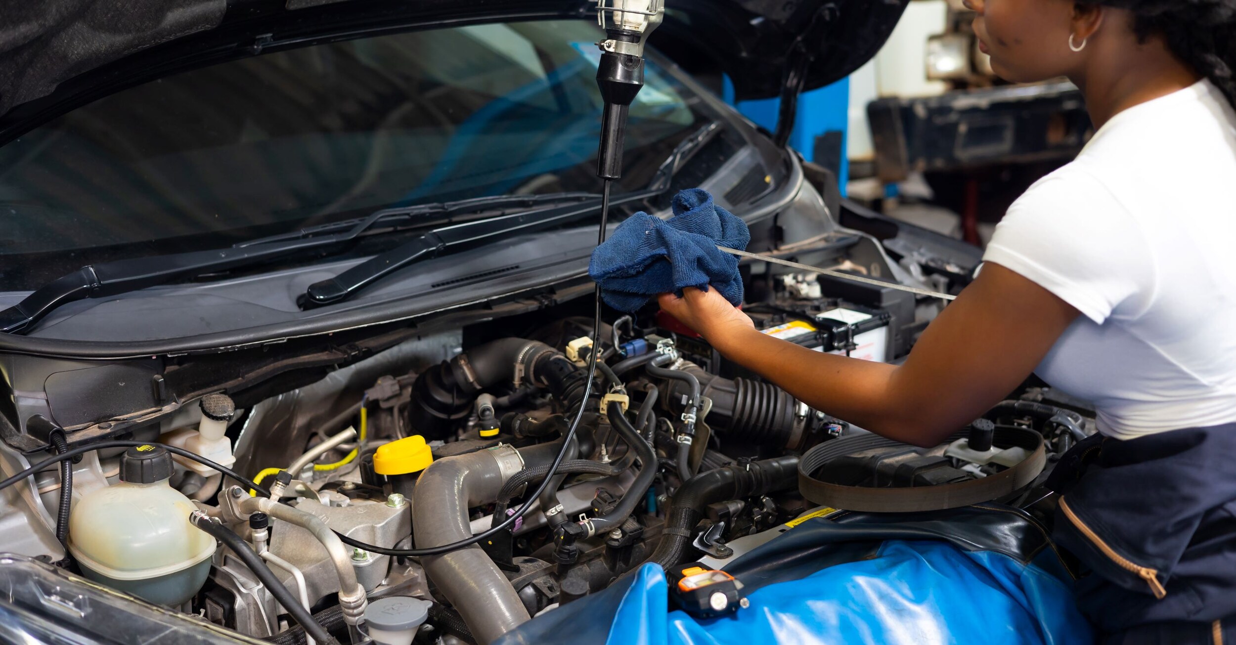 A car having its oil checked on by a mechanic.