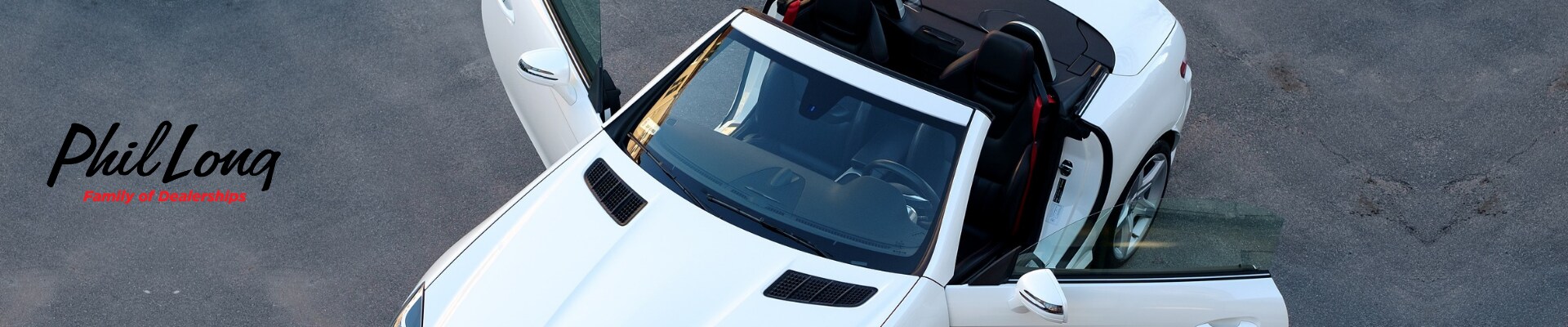 Bird eye view of a white used luxury car with both doors open inspecting the interior condition of the car
