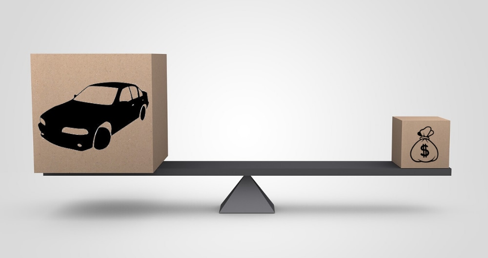 Illustrated image of a scale showing the value of a car trade-in outweighing the cash offers for the same car