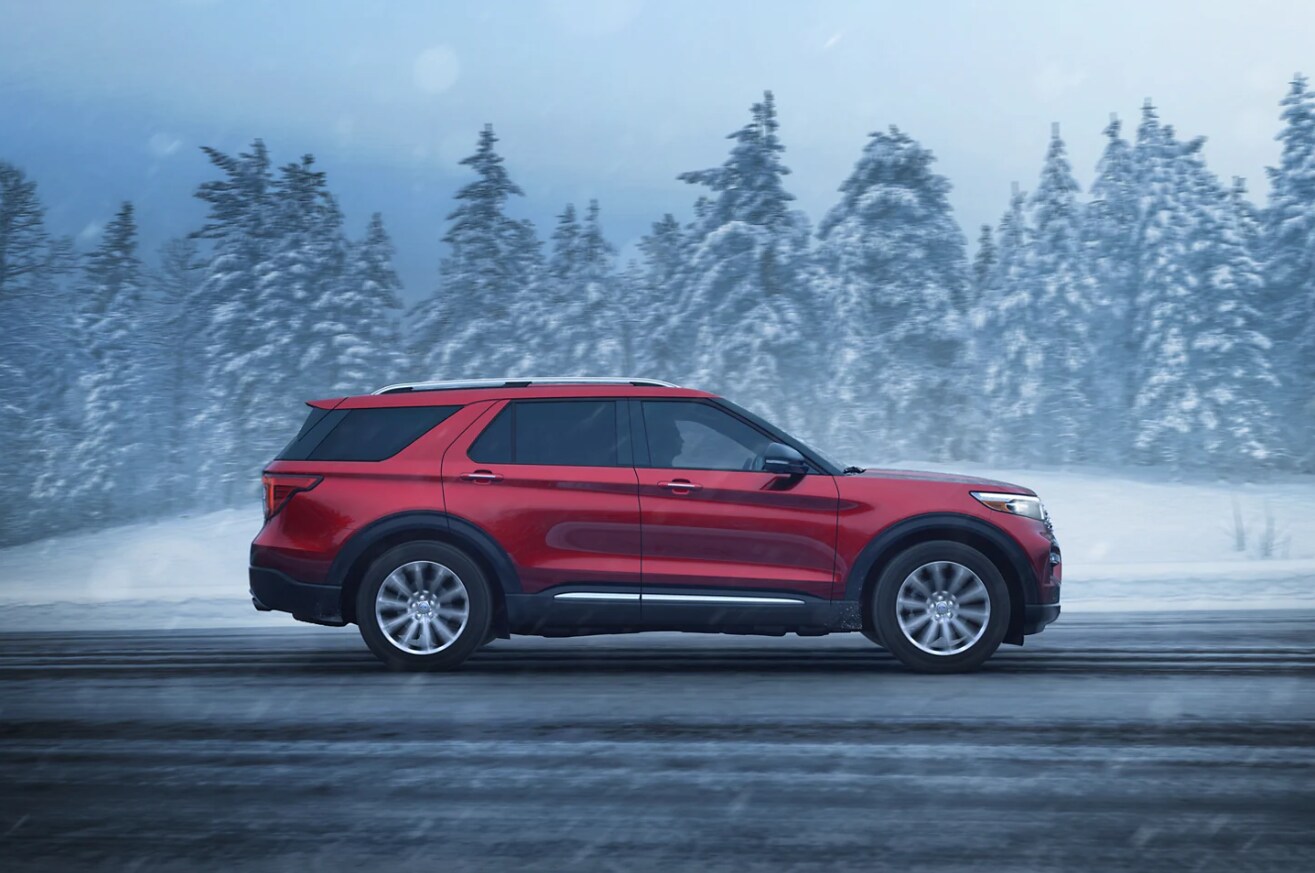 Red Ford Explorer driving on snowing road