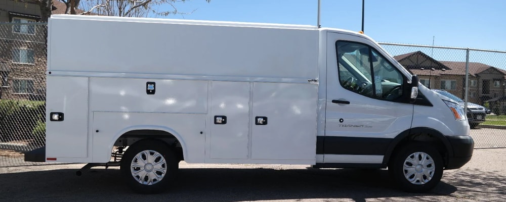 Passenger side of a new Ford commercial work van for sale in Denver at Phil Long Ford