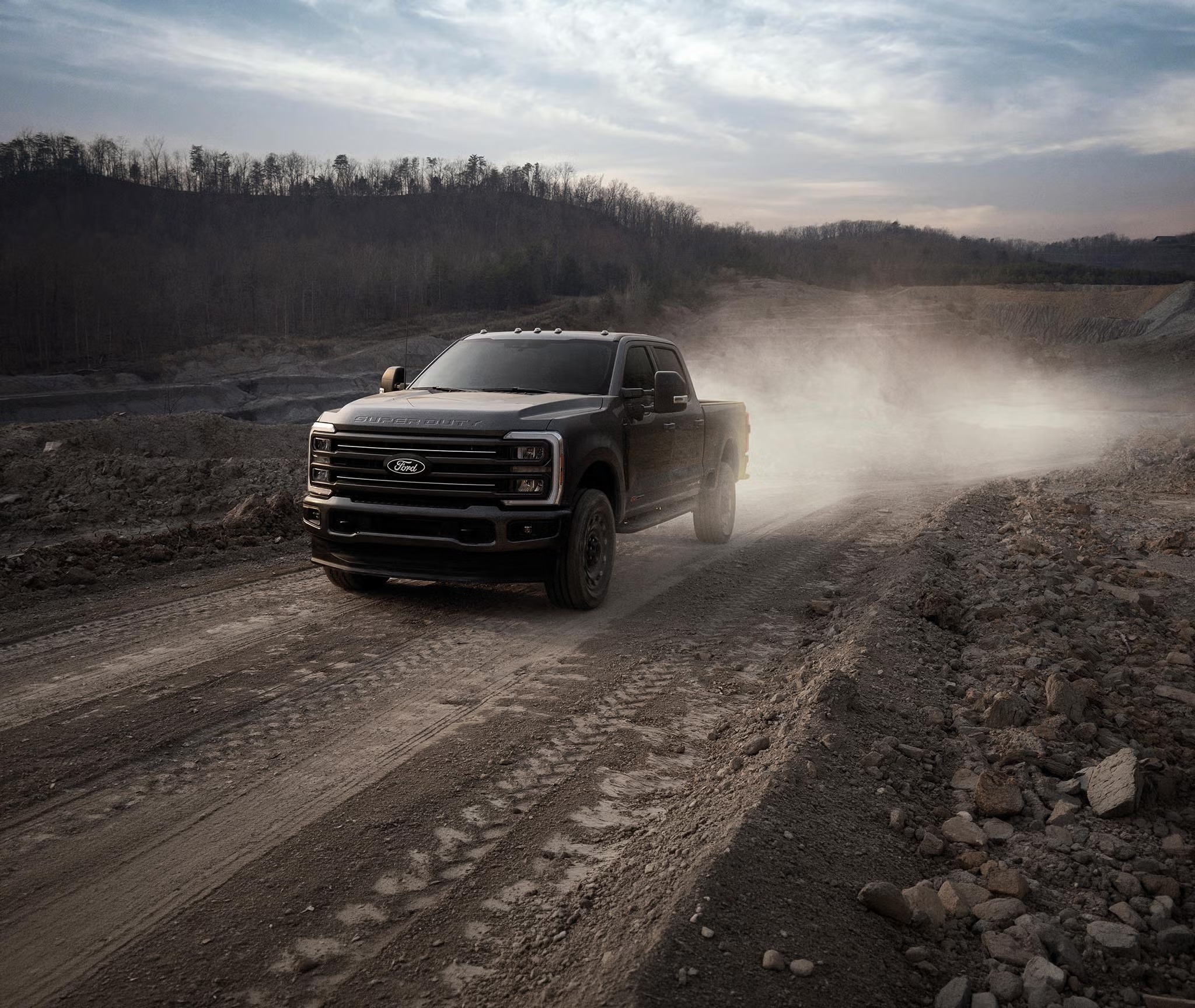 Ford Super Duty kicking up dust on a dirt road