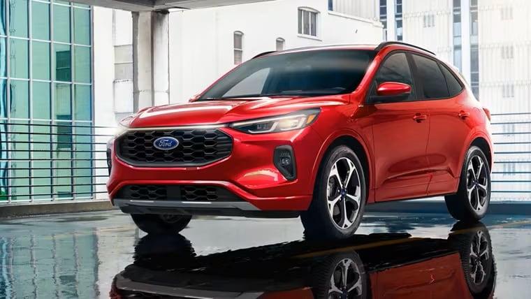 Red 2025 Ford Escape in a showroom in a city building.