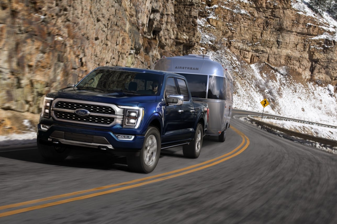 A new Ford F-150 driving up a mountain road towing a boat