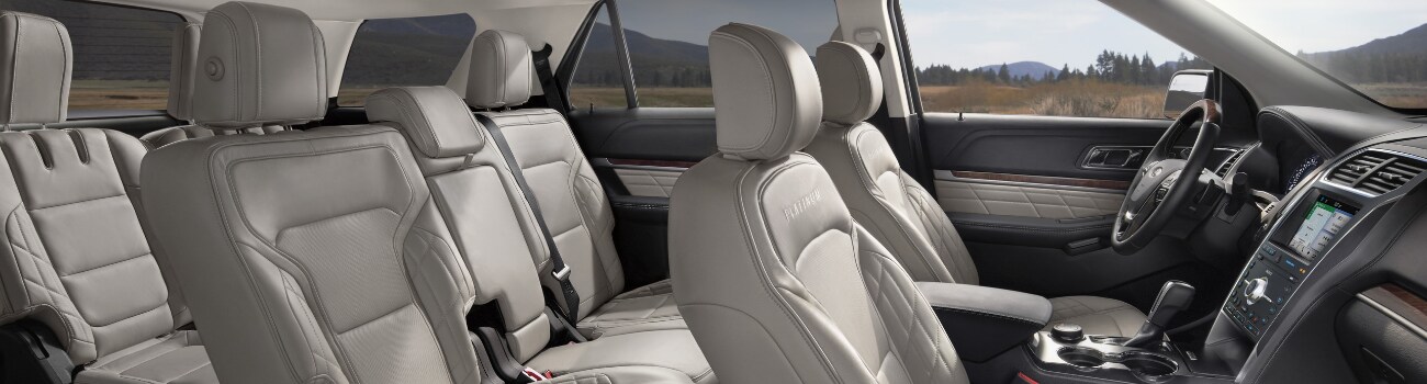 Interior view of a 2019 Ford Explorer from the passenger side showing the 3rd row seating and sleek infotainment system on the front dashboard