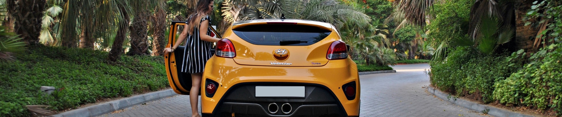 Hyundai Veloster rear exterior view as driver steps into the driver seat