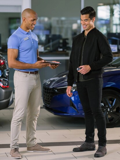 Hyundai service advisor reviewing service details with a customer on a tablet