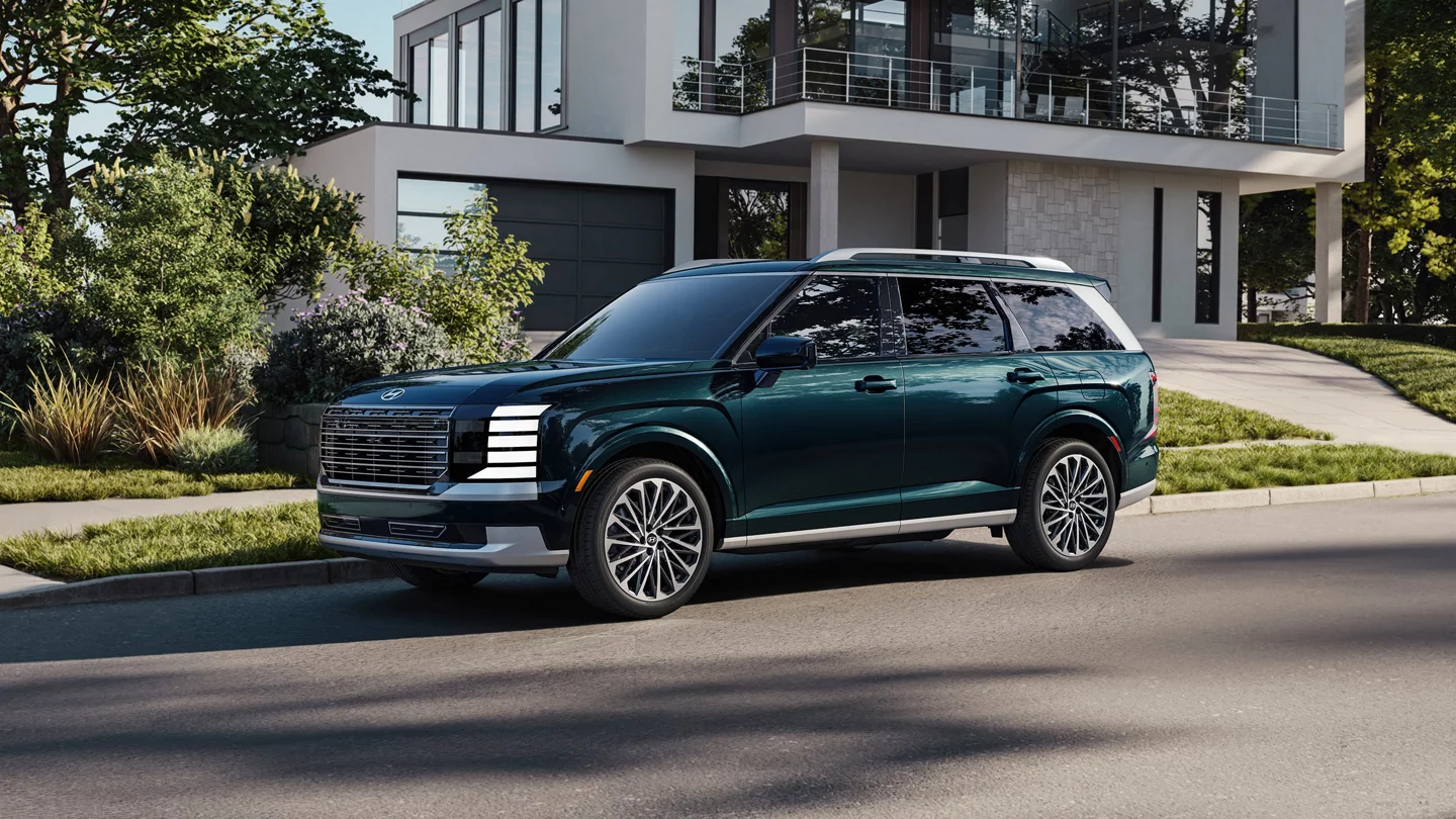 Exterior front three-quarter profile of the new 2027 Hyundai Palisade Calligraphy parked outside a contemporary suburban home