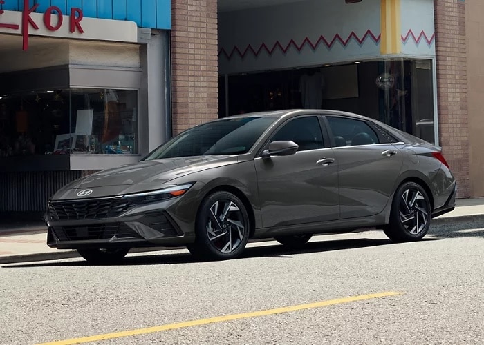 Gray 2026 Hyundai Elantra Hybrid sedan parked on a city street, front three-quarter view