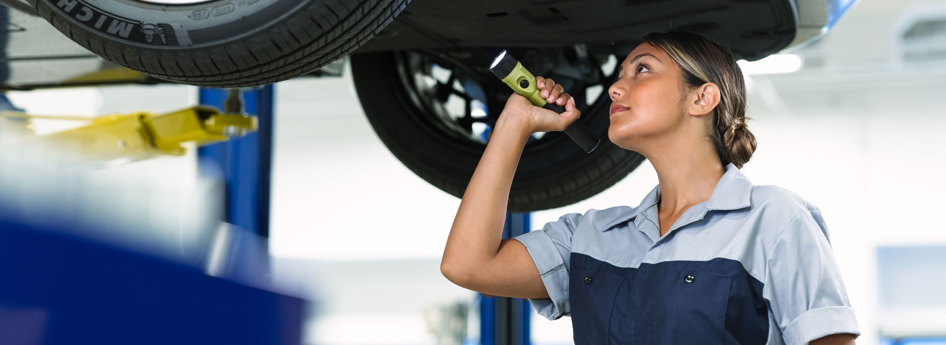 Hyundai service technician inspecting the underside of a vehicle on a lift at Phil Long Hyundai of Chapel Hills