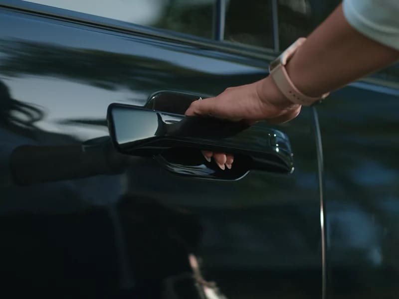 Passenger opening the door of a 2027 Hyundai Palisade Hybrid, where Safe Exit Assist can warn of approaching traffic