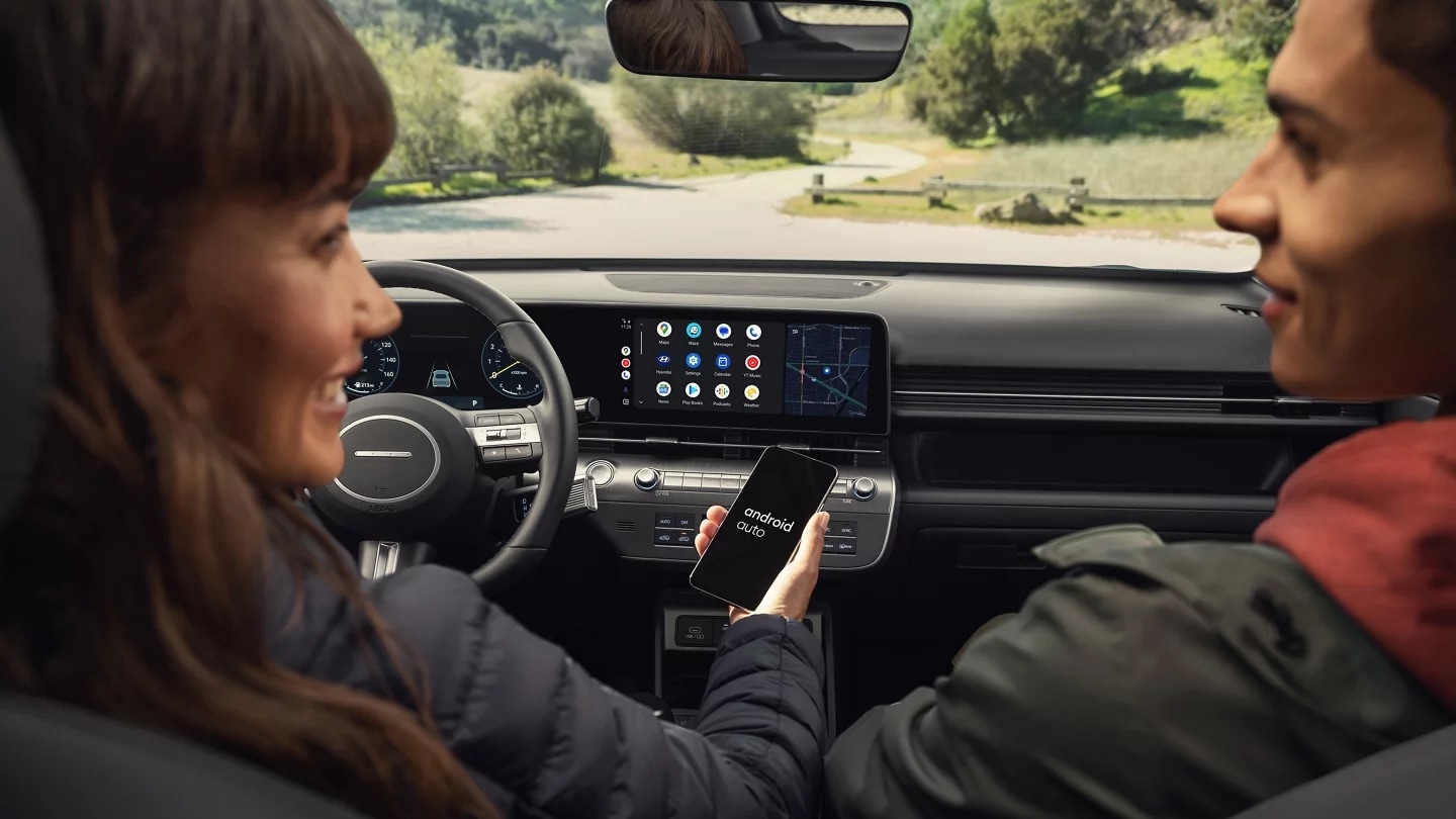 Driver and passenger using wireless Android Auto on the 2027 Hyundai Kona touchscreen