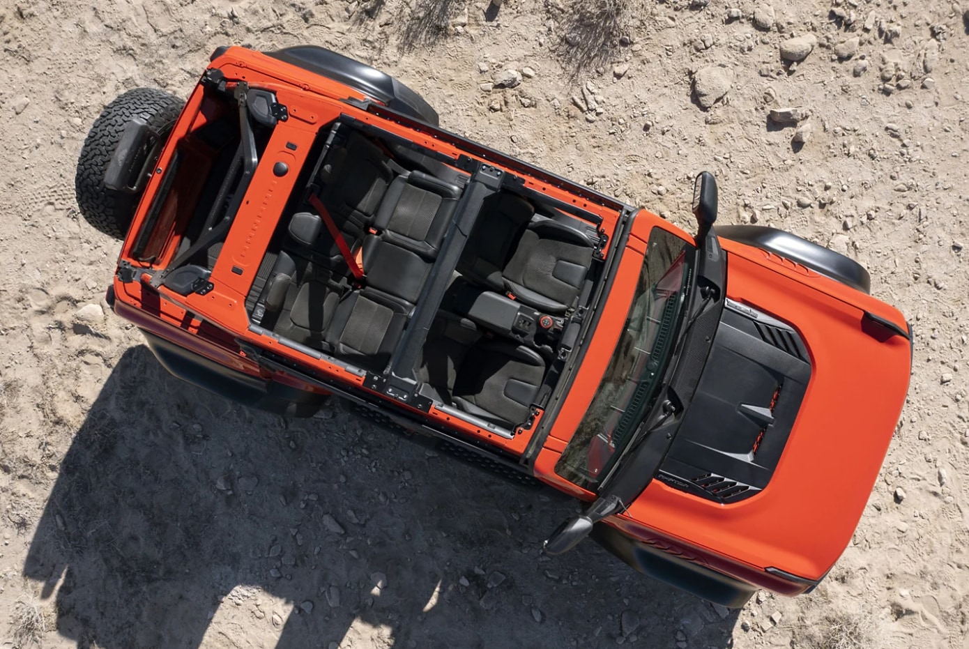 An overhead view of an orange 2023 Ford Bronco Raptor with the roof removed