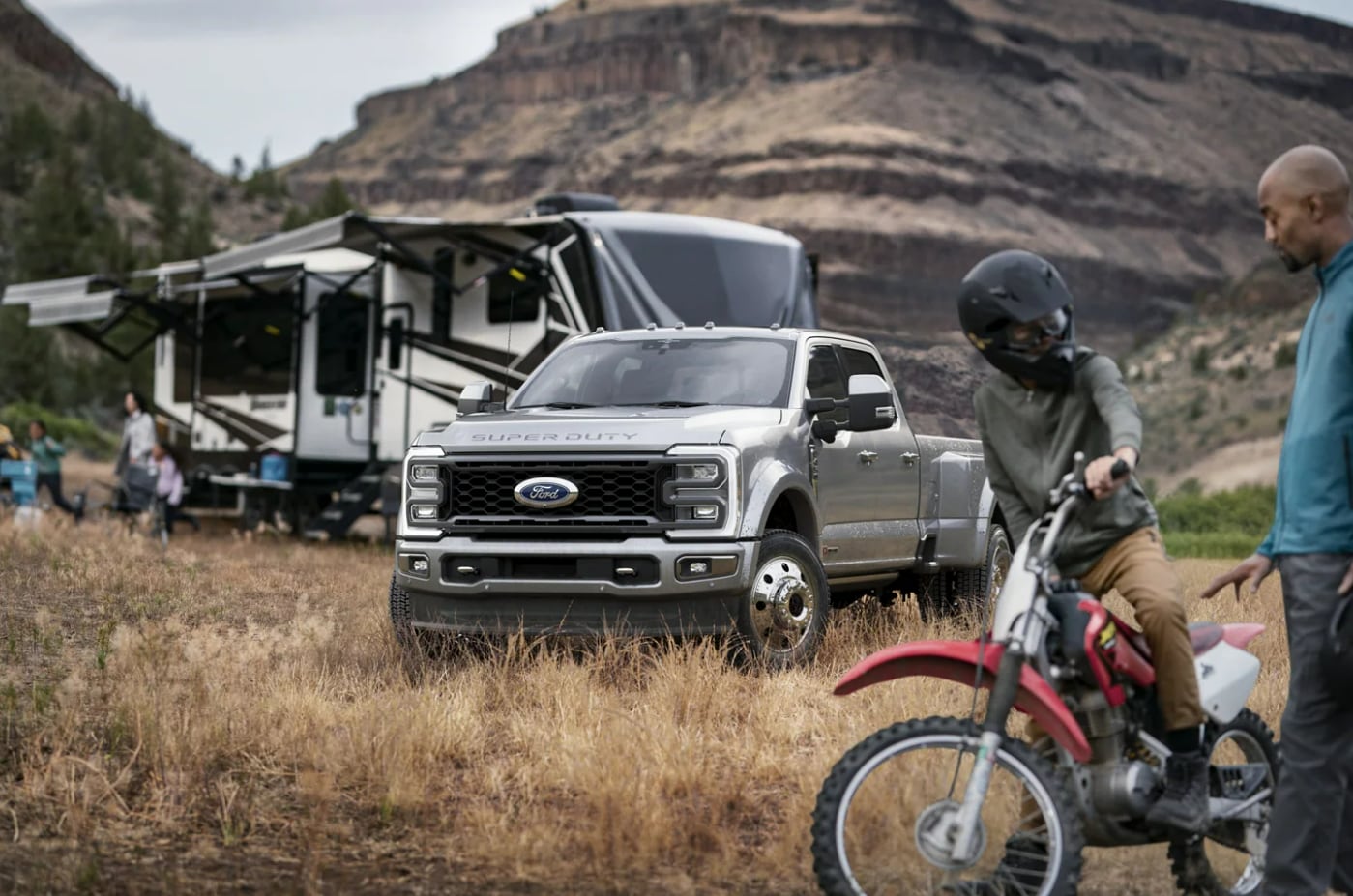 A Ford Super Duty pulling a camper with a dirt bike that was stored in the bed of the truck.